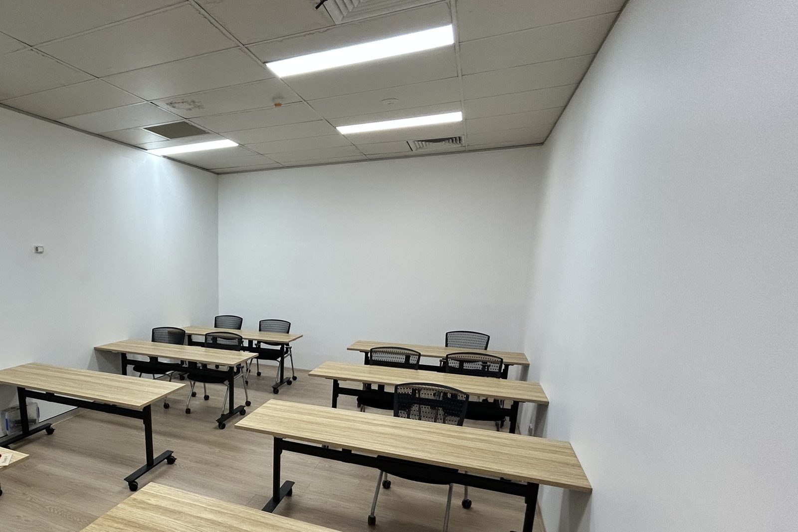 A bright classroom with rows of timber desks